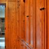 This Walk-In closet made from Red Oak and Natural Maple interiors features matching paneled walls, drawer base cabinets, roll out hampers, plenty of clothes hanging space, adjustable shelving and shoe cubbies.Also, a full length mirror, open glass shelf cabinet & pull out folding area. 